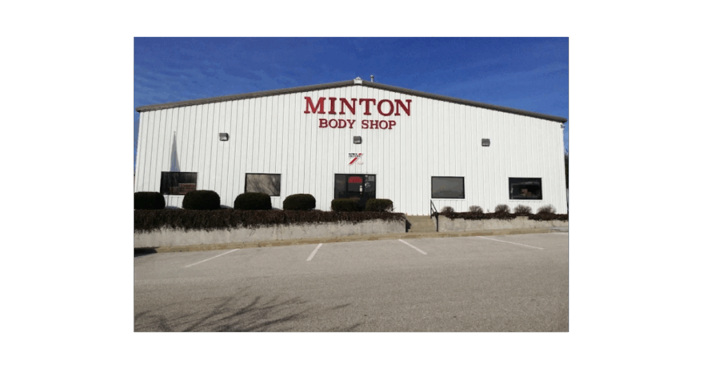 Front of Minton Body Shop, with red signage on white exterior, showing the frontdoors, and parking lots.